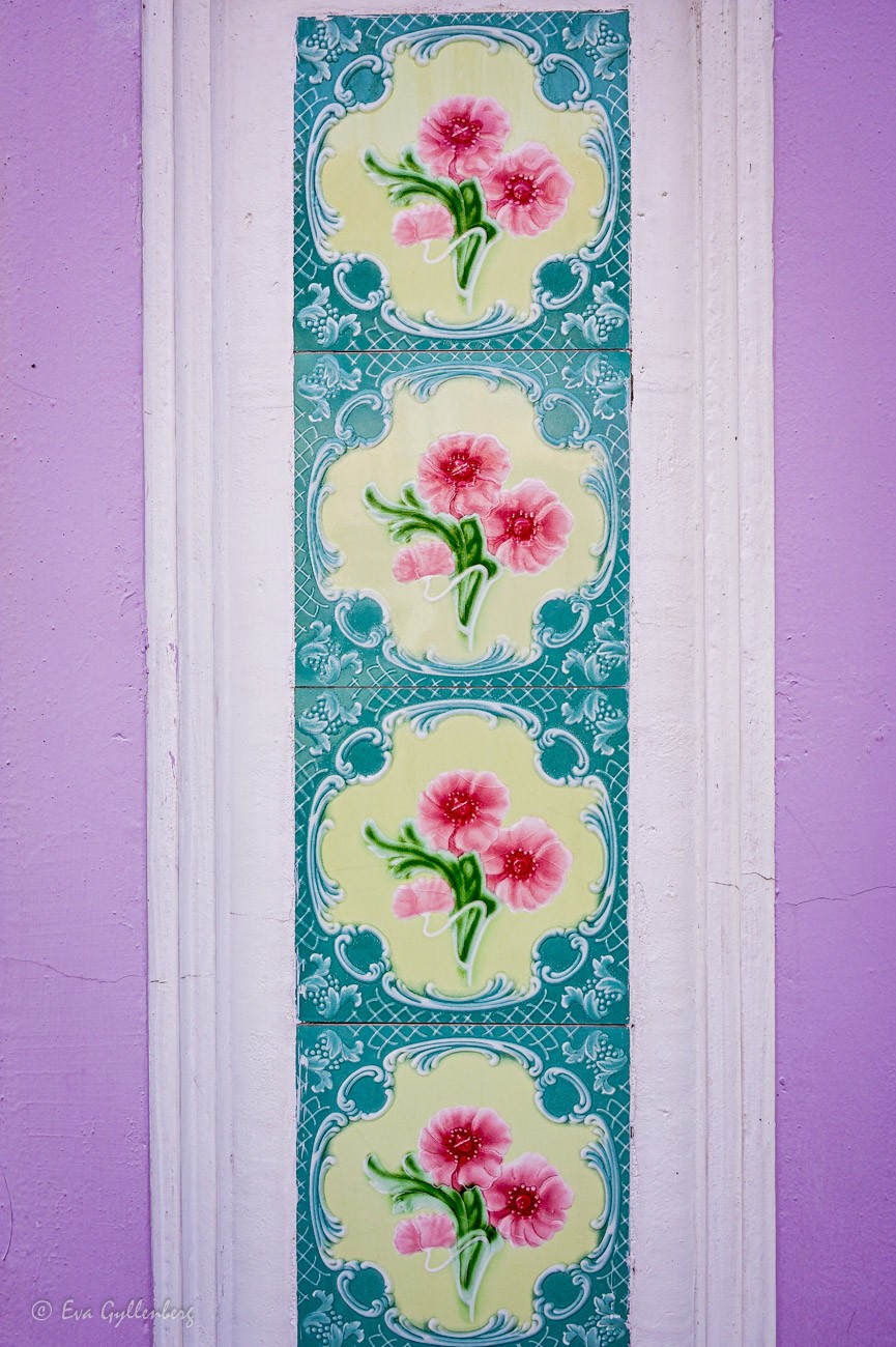 Peranakan tiles - Kakelplattor med blommor på en lila vägg