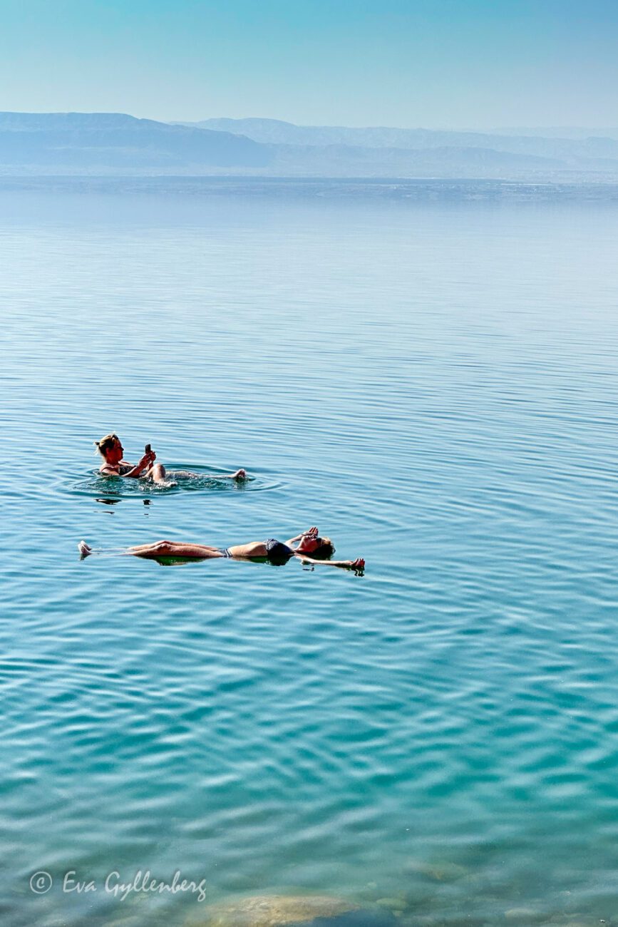 Två personer flyter i det turkosa Döda havet