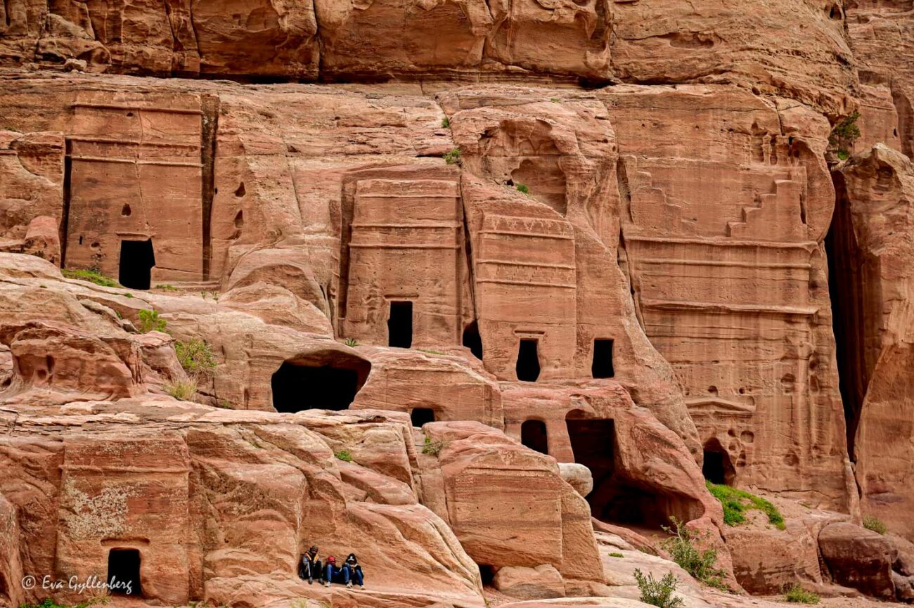 Klippgravar och kllippboningar i Petra med tre beduiner utanför