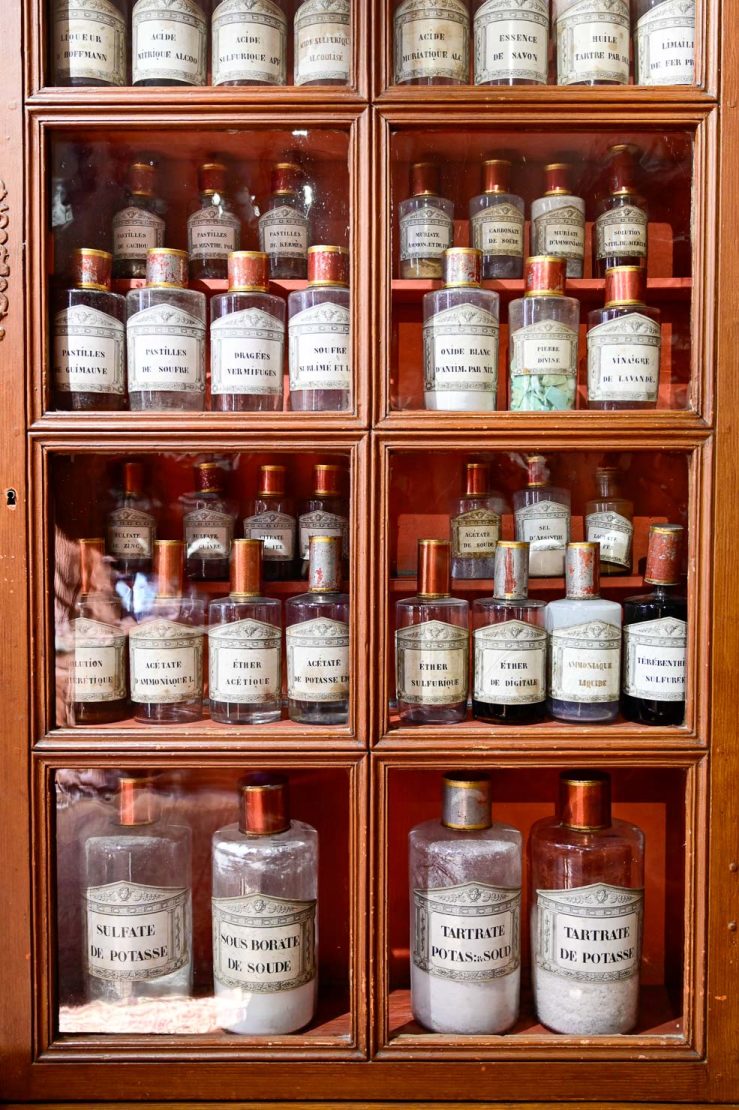 Historiska mediciner på rad i ett glasskåp