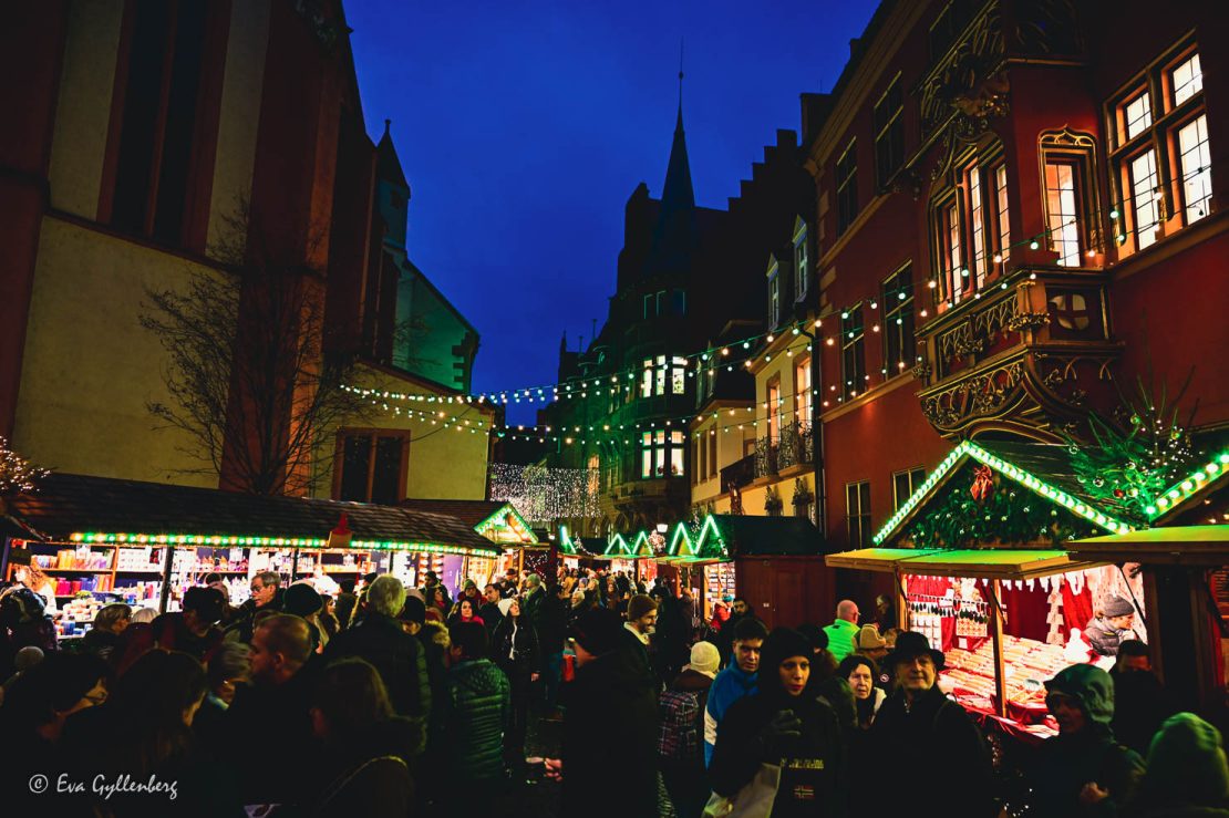 Julmarknad med marknadsstånd på båda sidor om en smala gatan