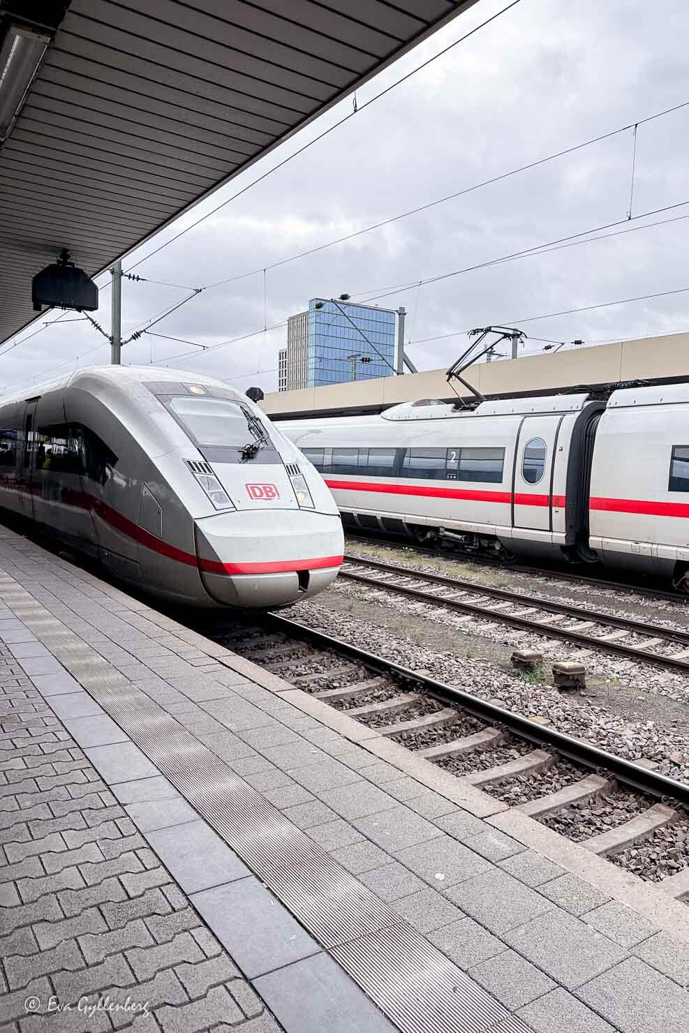 Åka tåg i Tyskland med snabba ICE-tåg på en perrong 