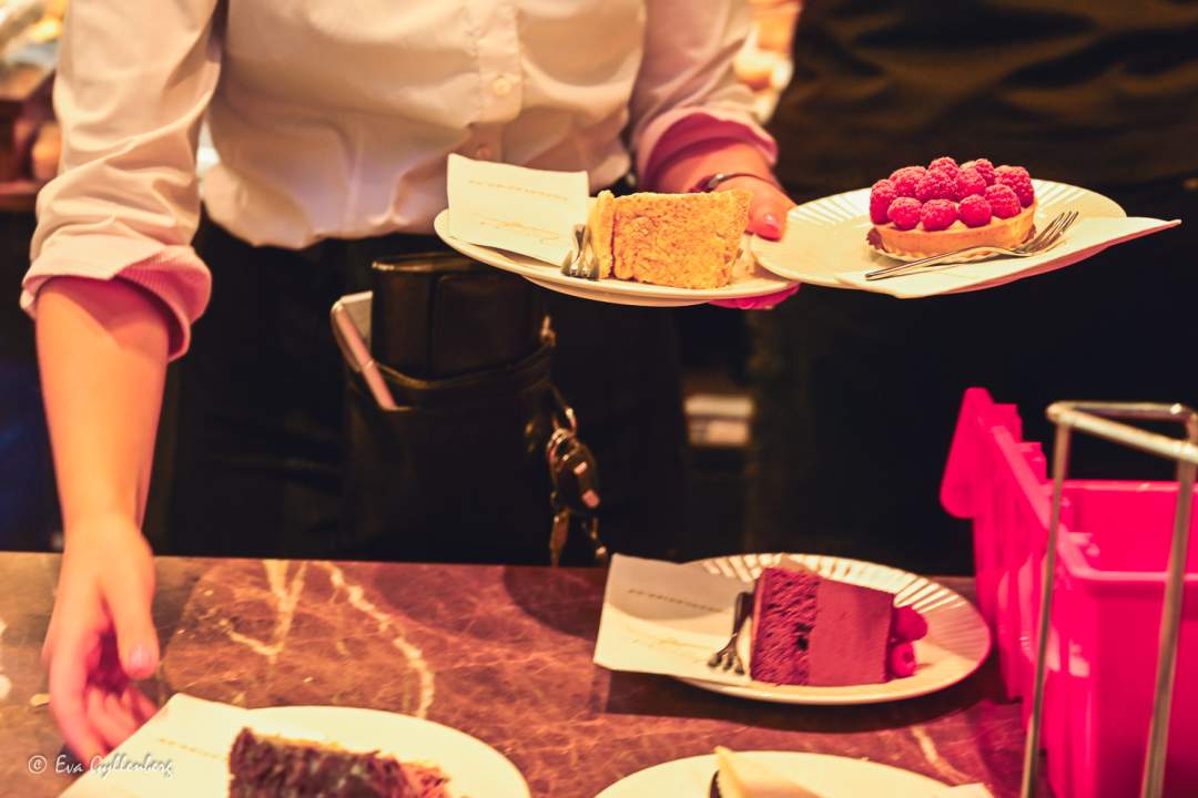 En servitris håller i tårtor och tarteletter