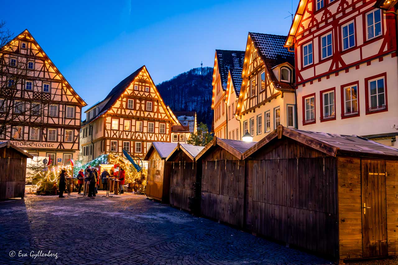Trästånd för julmarknader på den upplysta torget i Bad Urach