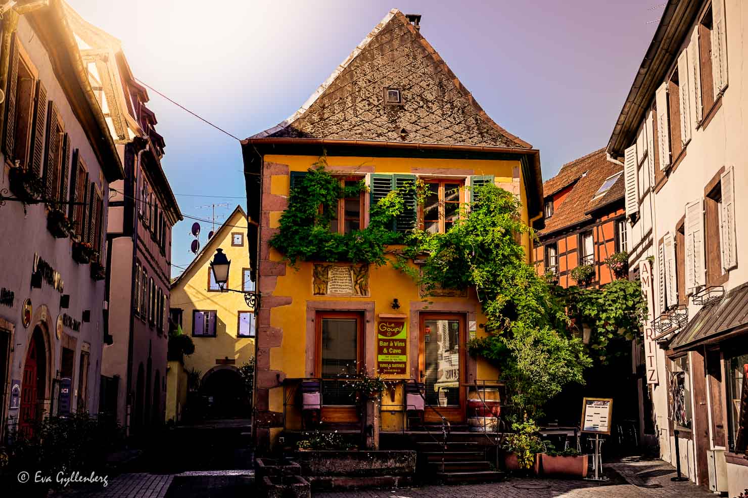 Charmigt gult hus på ett torg i Alsace