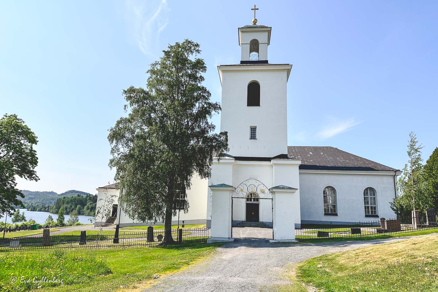 en vit kyrka vid en vacker havsvik