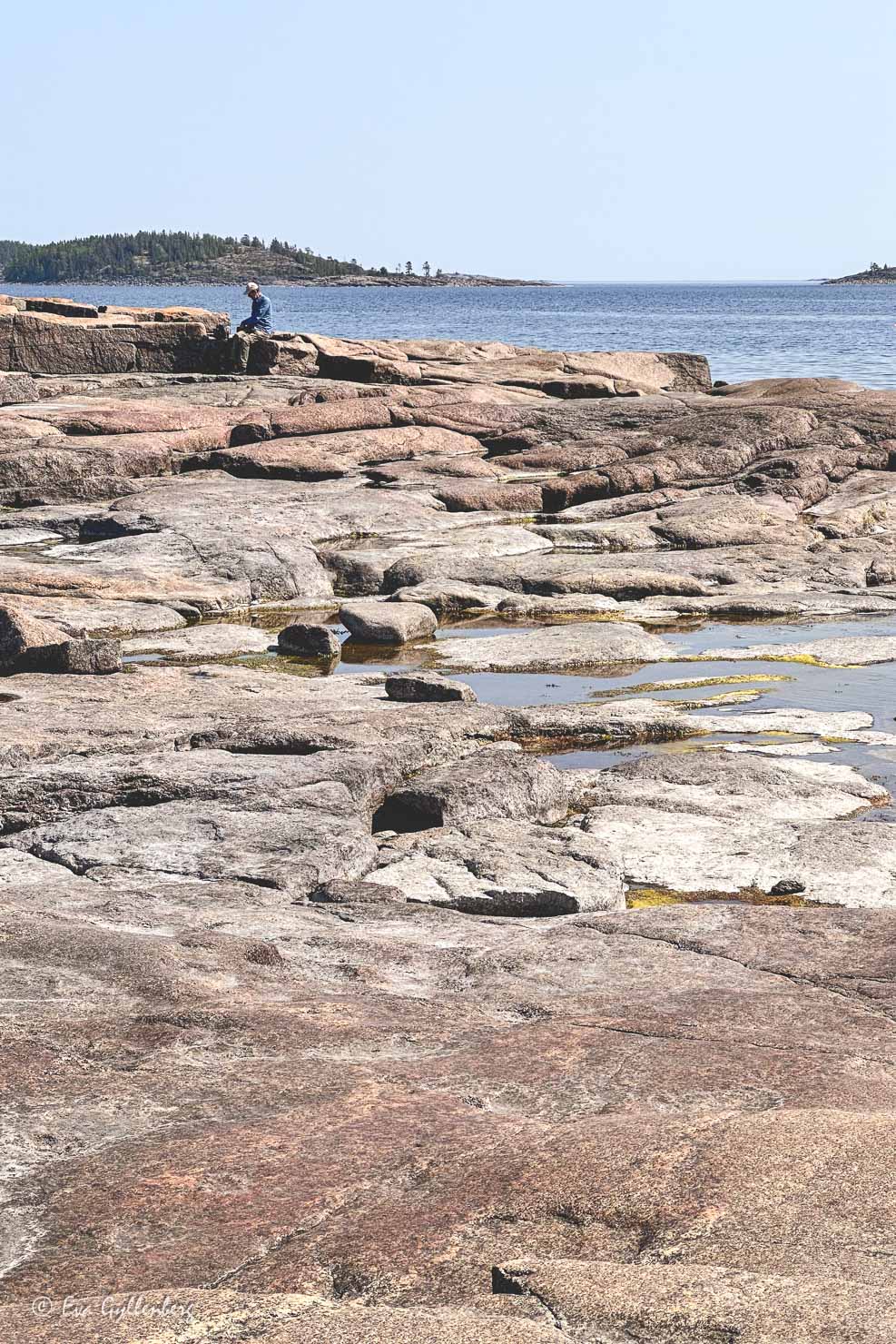 man sitter på en klippa vid havet