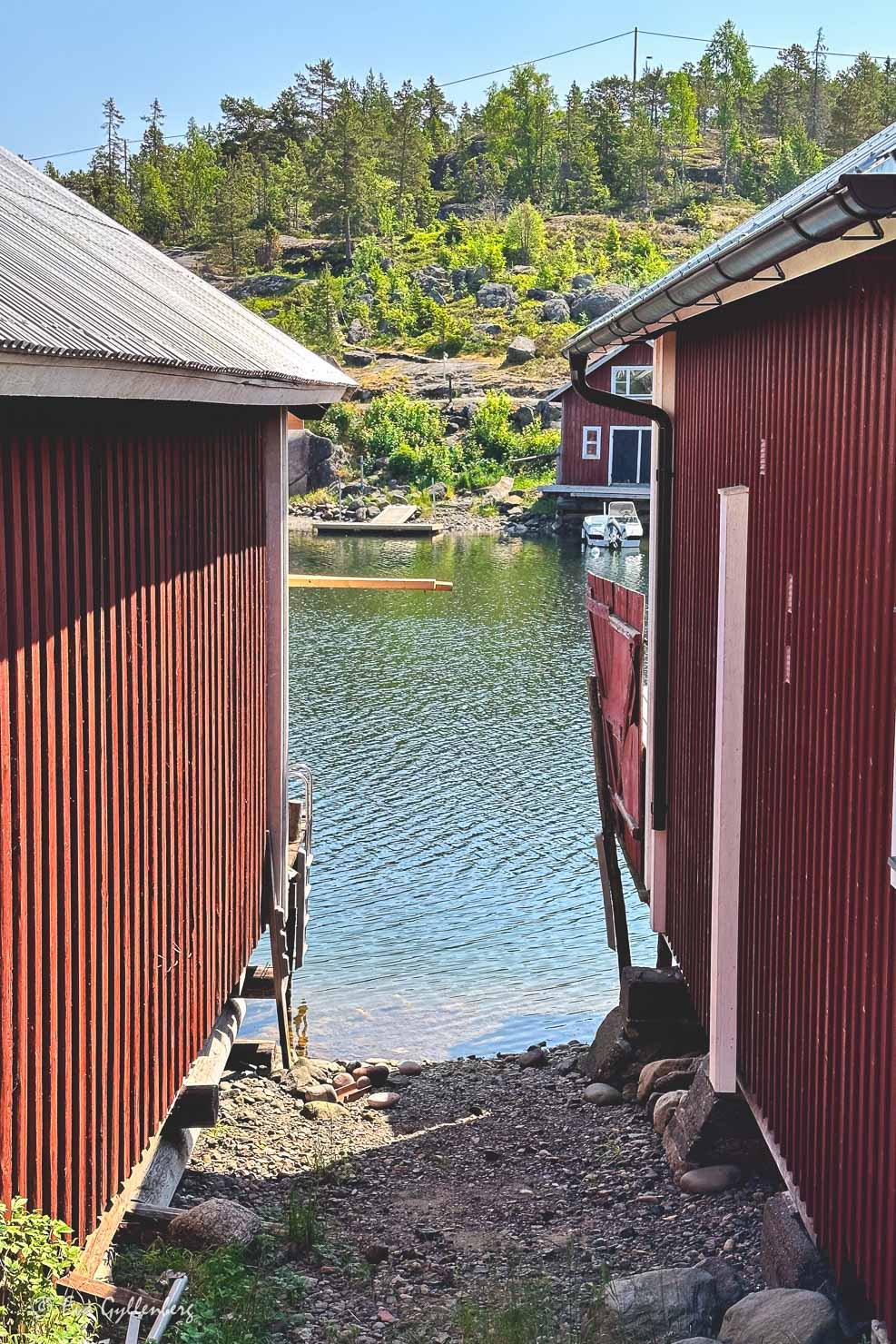 två röda trähus vid havet