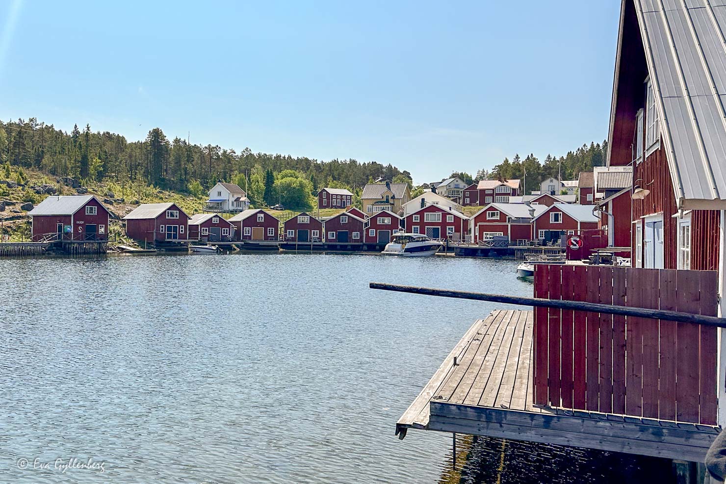 fiskeby med röda sjöbodar på rad