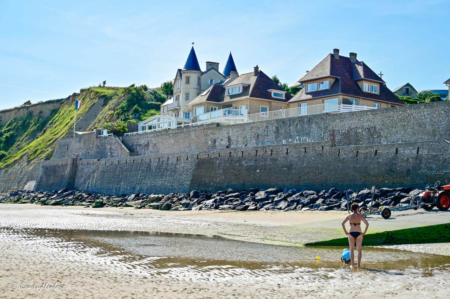 hus sedda från stranden med höga klippor 