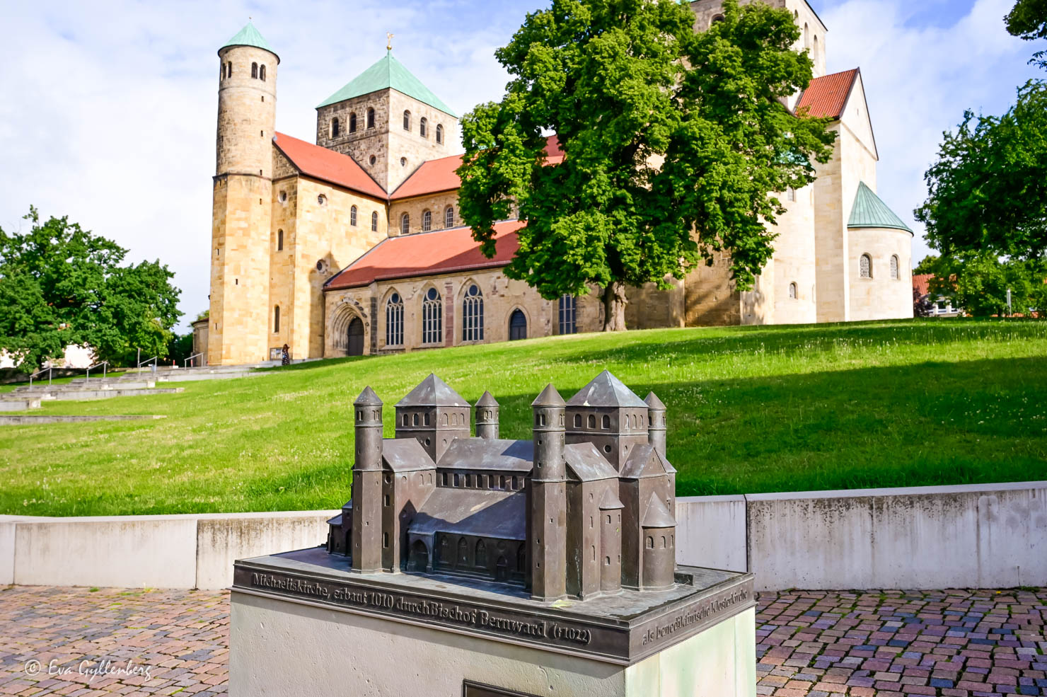 en historisk kyrka med en avbildning i brons framför