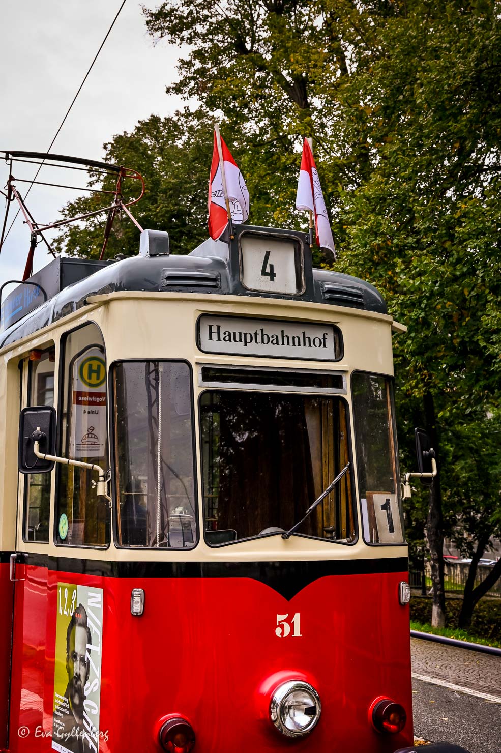 en röd spårvagn med flaggor