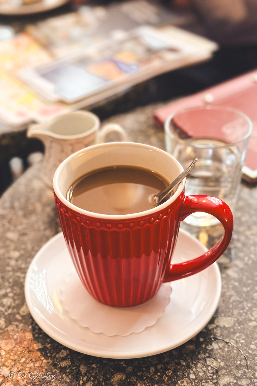 röd kaffekopp på ett stenbord på ett café