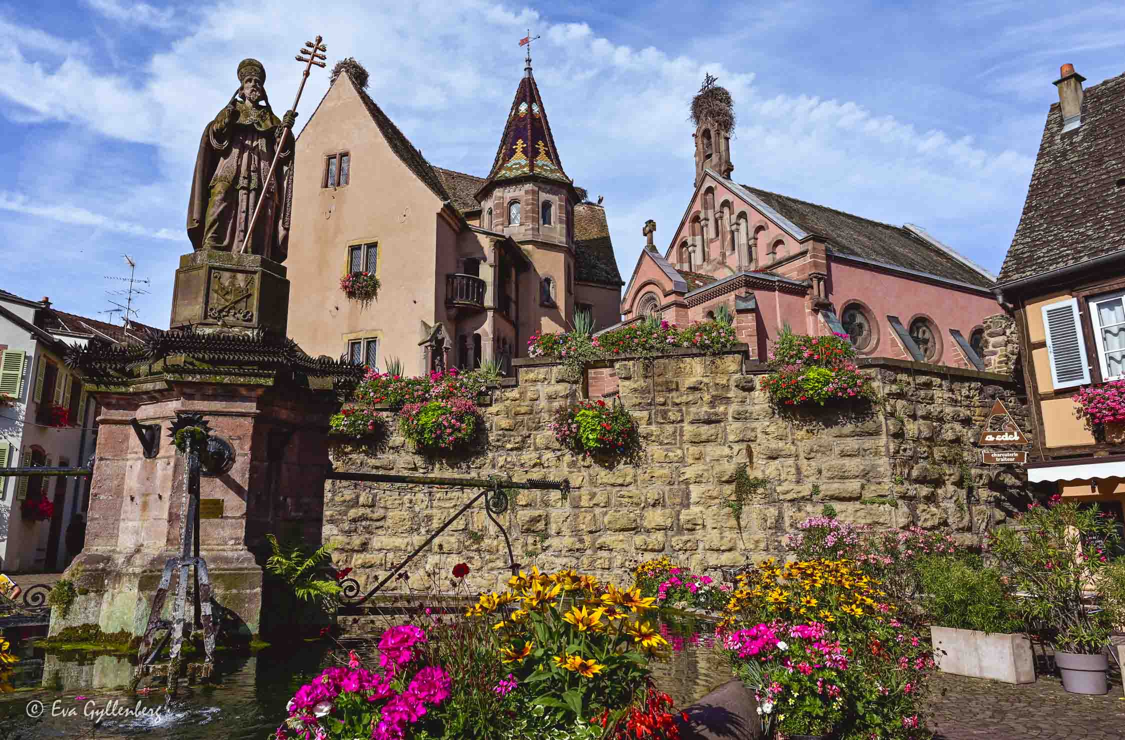 ett torg med en fontän i Eguisheim