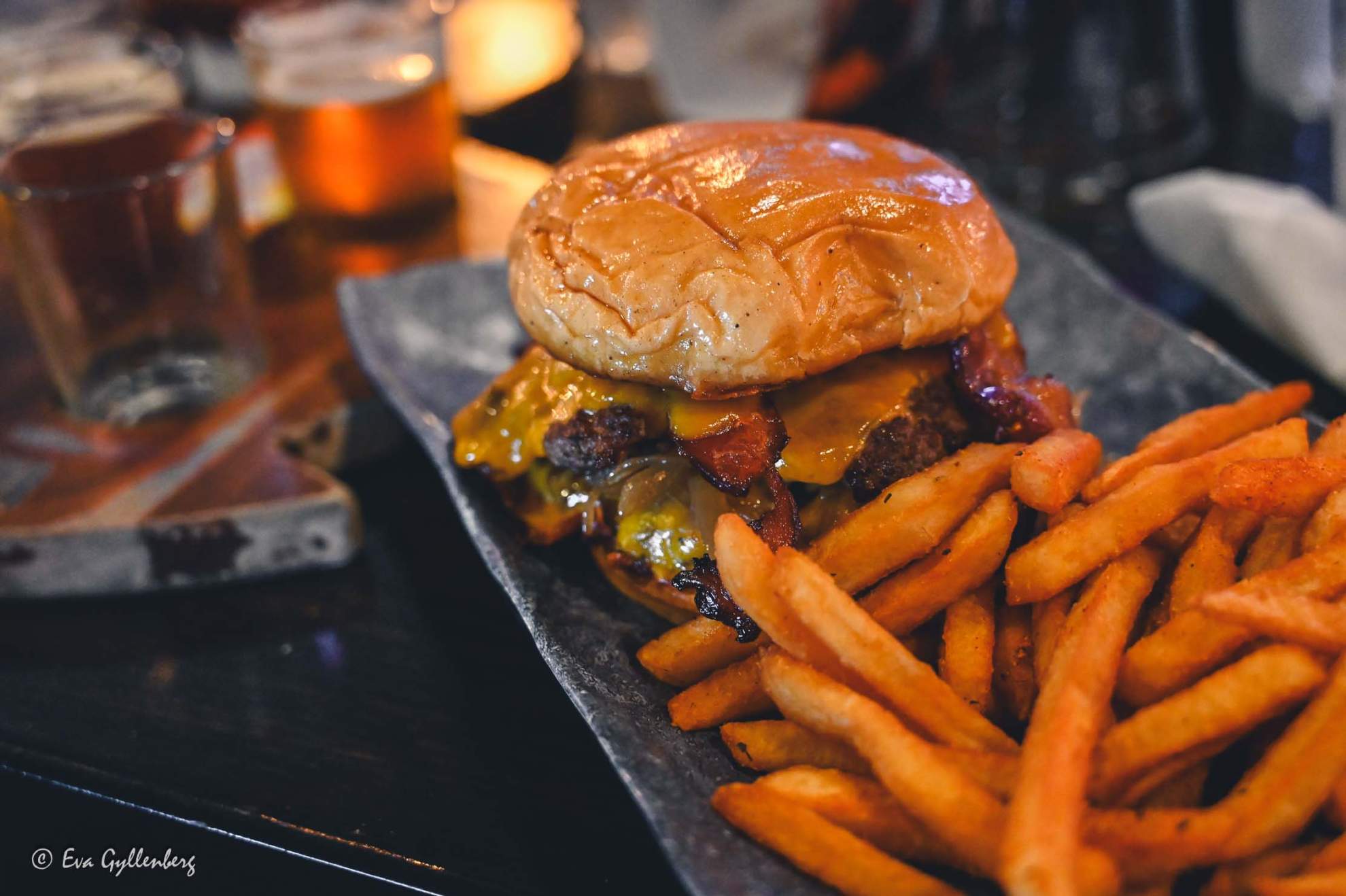 En grym smashed burger med pommes på ett bord