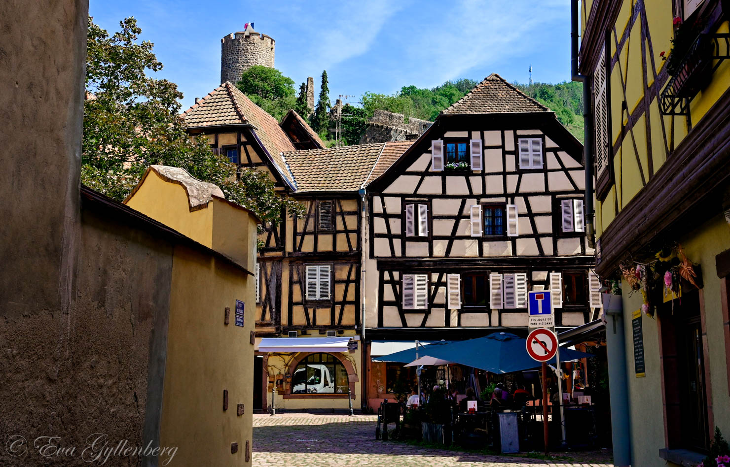 En by med korsvirkeshus i Alsace med en borg ovanför